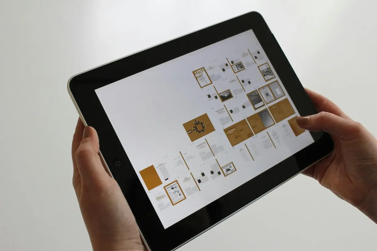 Hands holding a tablet showing website wireframes
